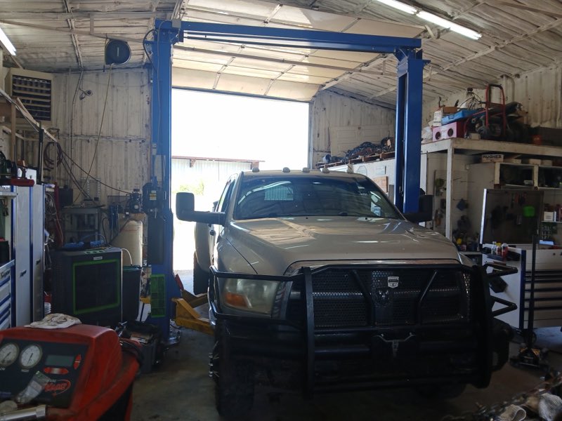 A truck raised on the two-post lift inside the service bay